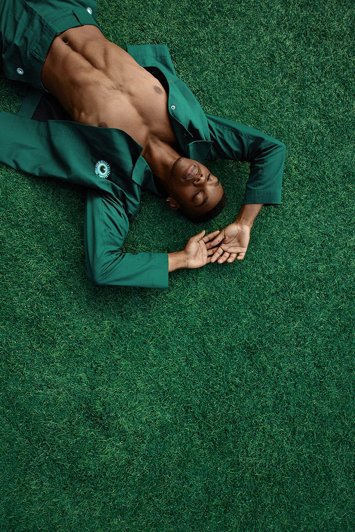 a man laying on the ground with his hands in his pockets and one hand under his chest