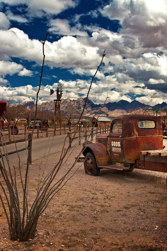 an old truck is parked on the side of the road