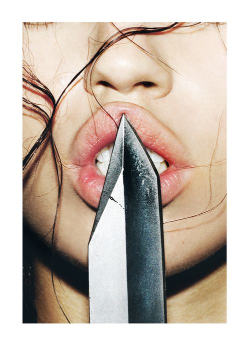 a woman holding a pair of scissors in her mouth with the image of an arrow sticking out of it