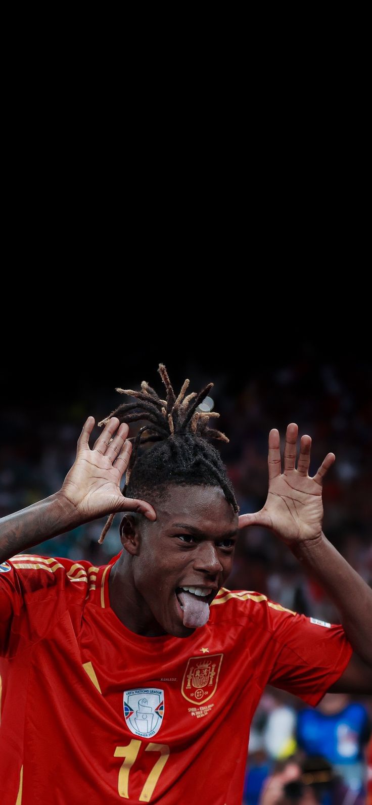 a man with dreadlocks on his head and hands in the air as he celebrates