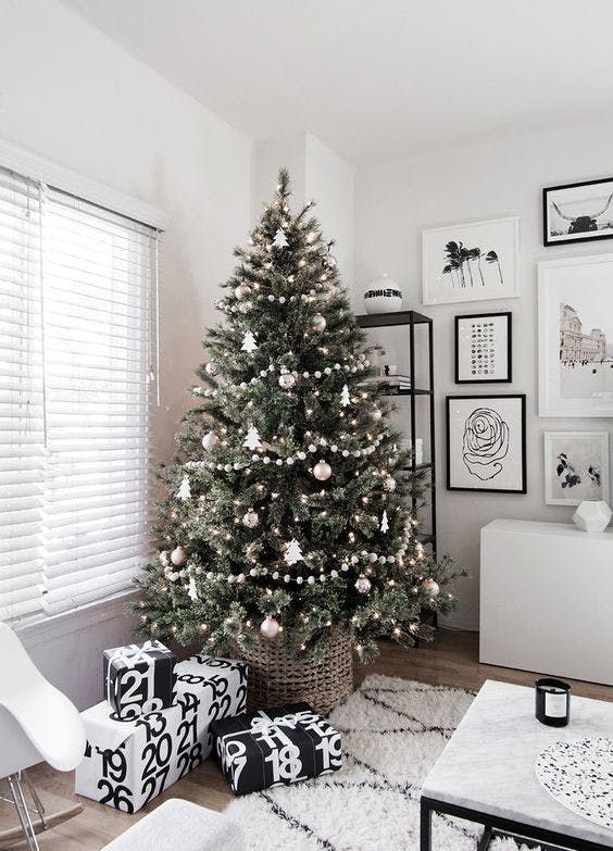 a decorated christmas tree in a living room with black and white decorations on the walls