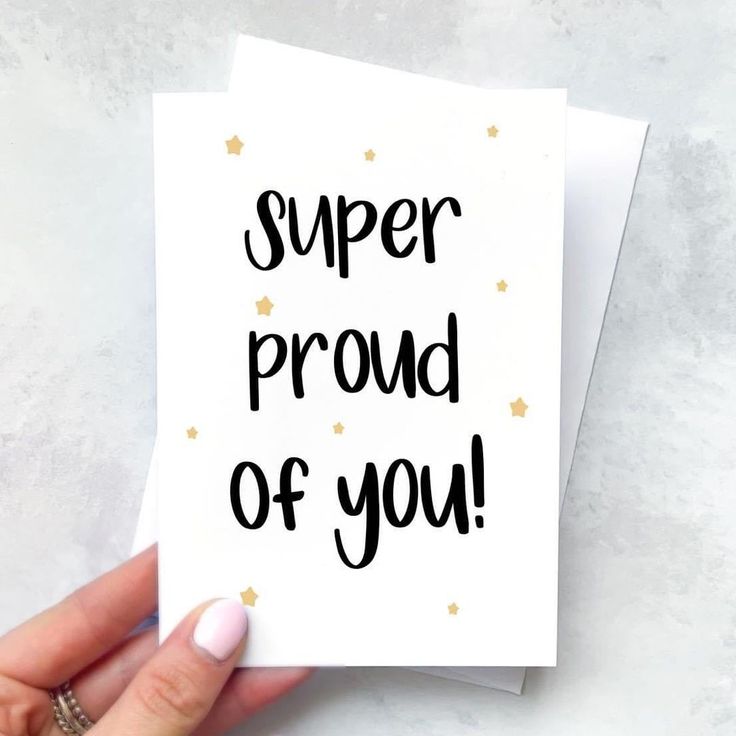 someone holding up a card with the words super proud of you written in black on it