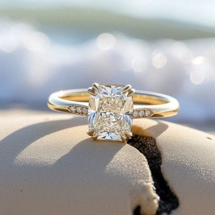 a diamond ring sitting on top of a sandy beach