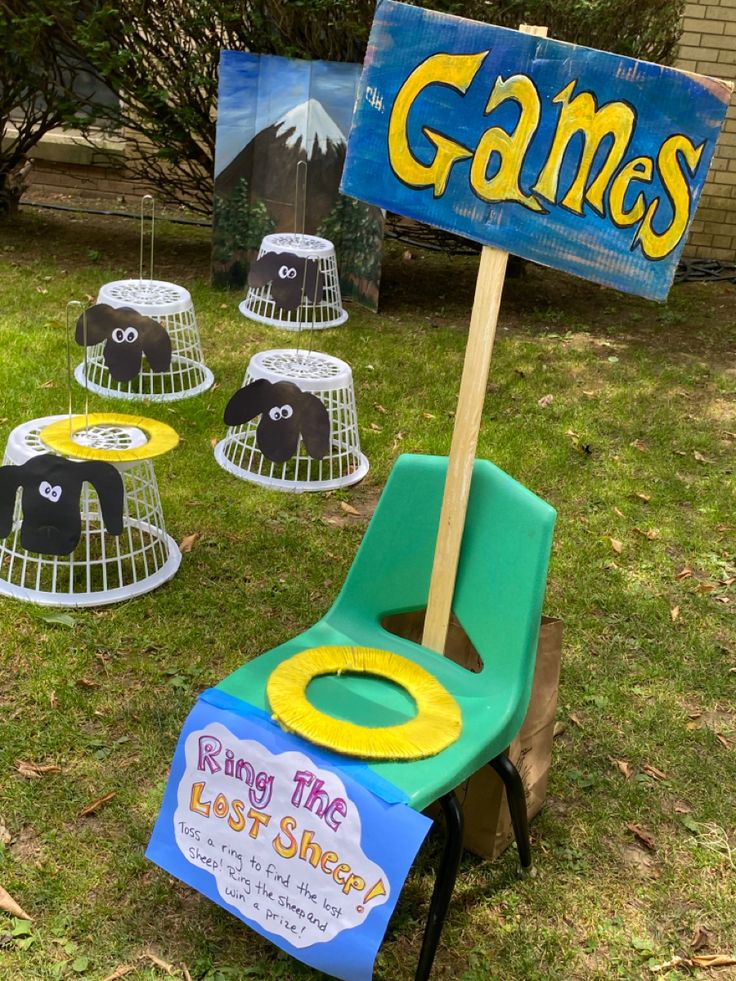 a chair sitting in the grass next to a sign that says game's on it