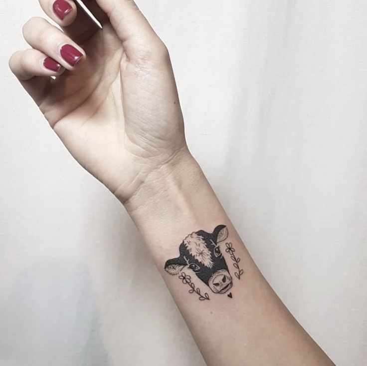 a woman's arm with a tattoo on it and a skull in the middle