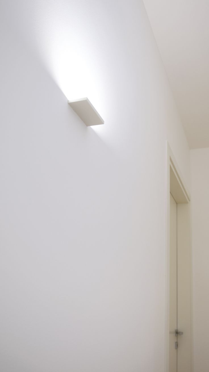 a white room with a light on the wall