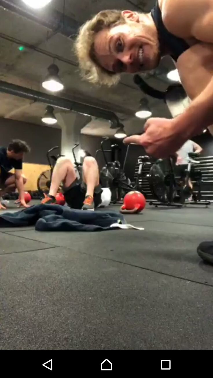 a group of people doing push ups in a gym