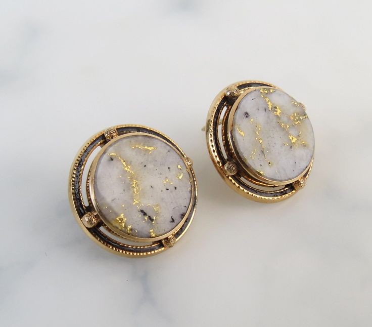 "The simple 14k yellow gold bezel-settings showcase the round gold-in-quartz stones within these antique 1910s earrings. Black enamel rings and textured spheres frame the stones nicely. Gold-Bearing Quartz is one of the world's rarest forms of natural gold. It is found underground by hard rock miners in only a few locations in the world. The natural veins of pure gold were formed in quartz by hydrothermal pressure deep within the earth millions of years ago. The flat polished gems are of white t Luxury Round Cabochon Clip-on Earrings, Formal Gold Bezel Set Earrings, Formal Round Clip-on Earrings With Polished Finish, Formal Polished Round Clip-on Earrings, Formal Polished Clip-on Earrings, Antique Round Earrings For Evening, Gold Gemstone Clip-on Earrings For Formal Occasions, Formal Gold Gemstone Clip-on Earrings, Round Brass Jewelry With Bezel Setting