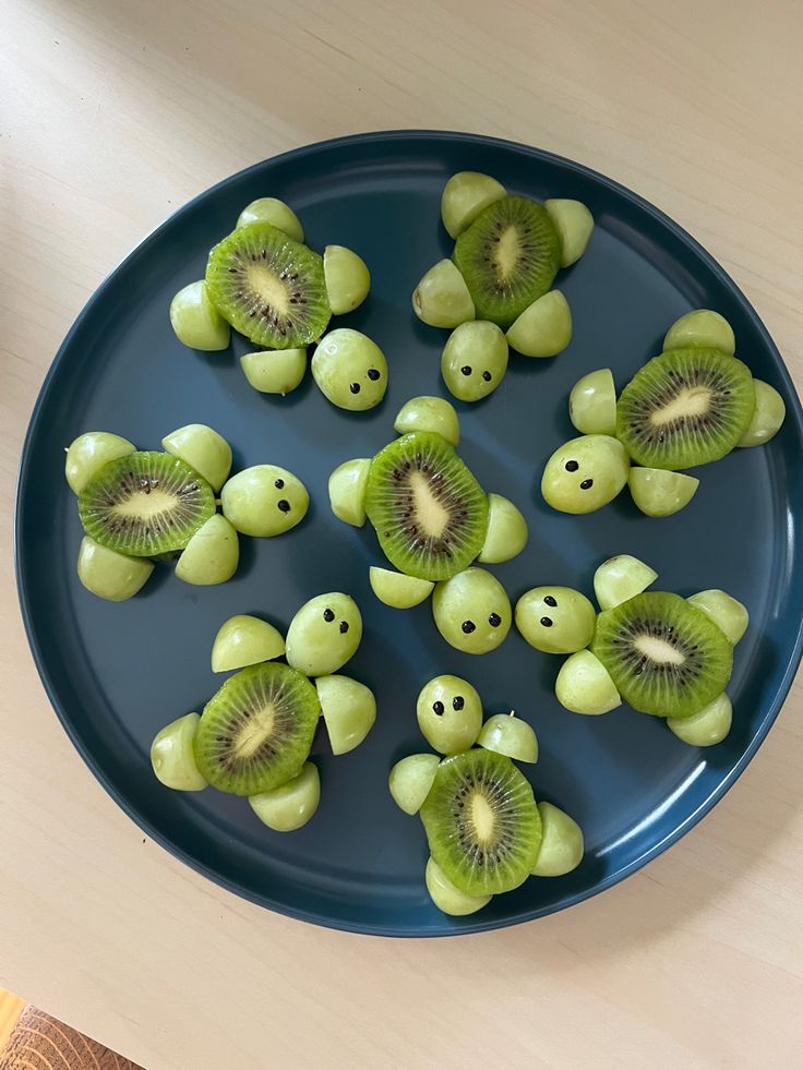 sliced kiwis in the shape of smiley faces on a blue plate