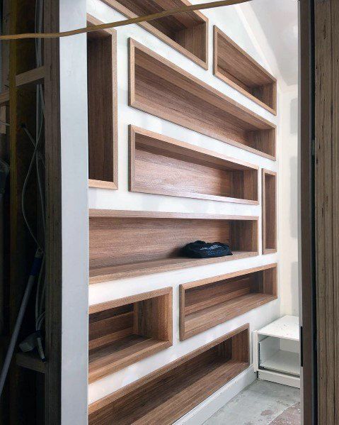 a room with wooden shelves and white walls