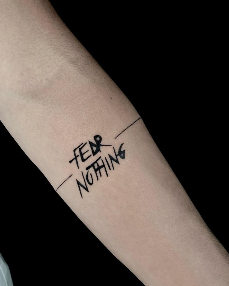 a person's arm with the words fear, nothing written on it in black ink