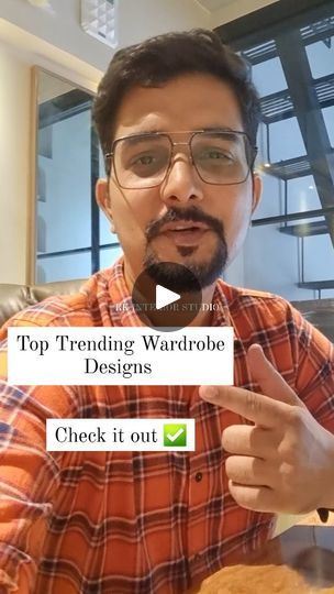 a man in an orange shirt is pointing to the screen with words on it that read top trending wardrobe designs check it out