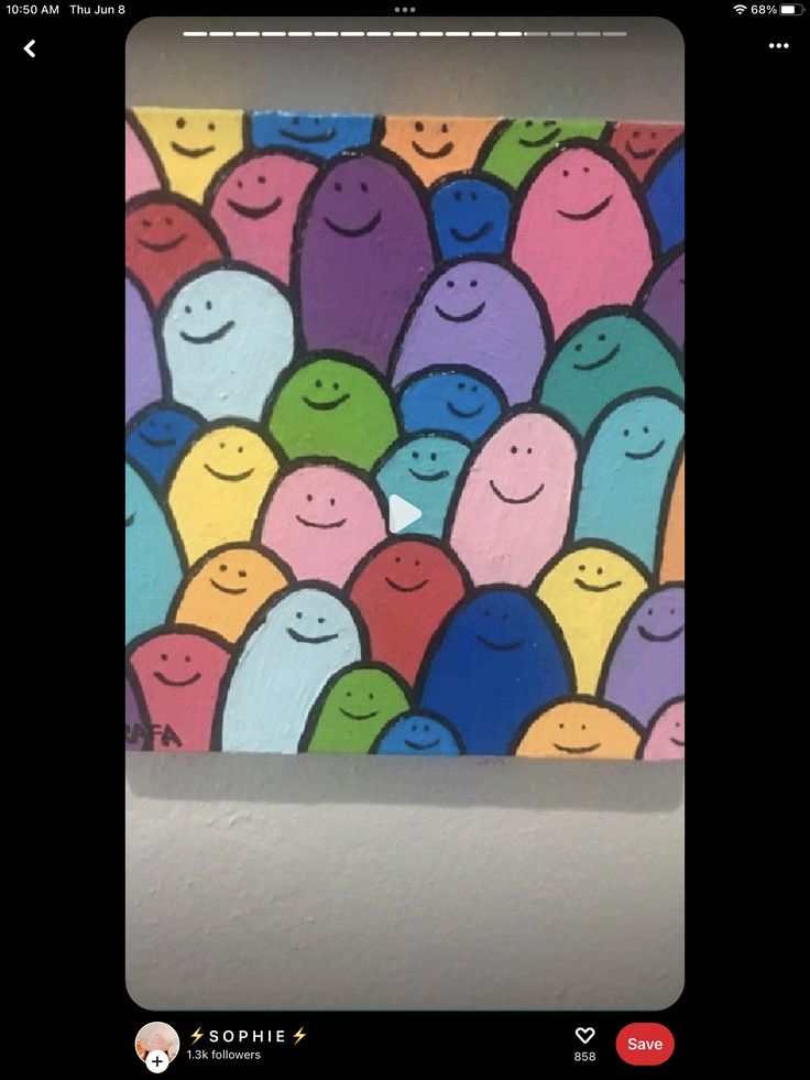 a painting of many smiling faces on a white wall