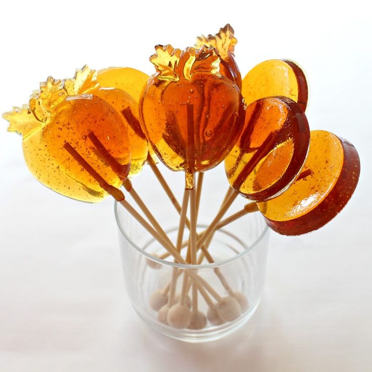 a glass filled with lollipops sitting on top of a white countertop