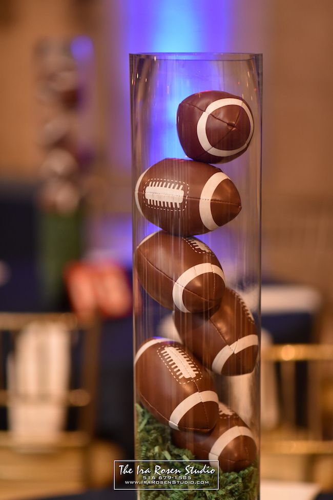 four chocolate footballs in a glass vase on a table