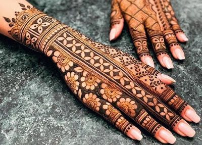 two hands with henna tattoos on them, one is showing it's intricate designs