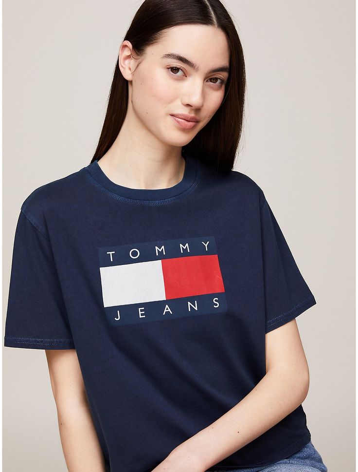 Tommy Hilfiger women's T-shirt. This pure cotton T-shirt is proudly printed with the iconic Tommy flag badge, making it a streetwear wardrobe hero. Part of our Tommy Jeans collection.  Material: 100% Transitional Cotton ,  In-conversion. Blue Crew Neck Top With Logo Patch, Blue Cotton Tops With Logo Patch, Blue Casual Tops With Logo Patch, Casual Blue Tops With Logo Patch, Casual Short Sleeve T-shirt With Logo Emblem, Casual Cotton T-shirt With Logo Emblem, Trendy Tommy Hilfiger Cotton T-shirt, Graphic Tee With Logo Emblem And Short Sleeves, Graphic Cotton T-shirt With Logo Patch