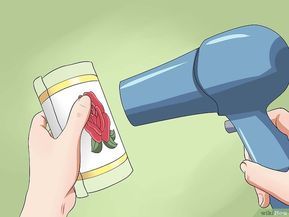 a hand holding a blue blow dryer and a can of chili peppers next to it