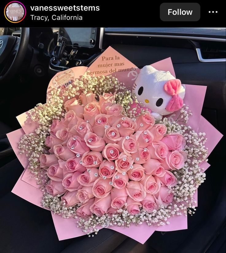 a bouquet of pink roses and hello kitty in the back seat of a car,