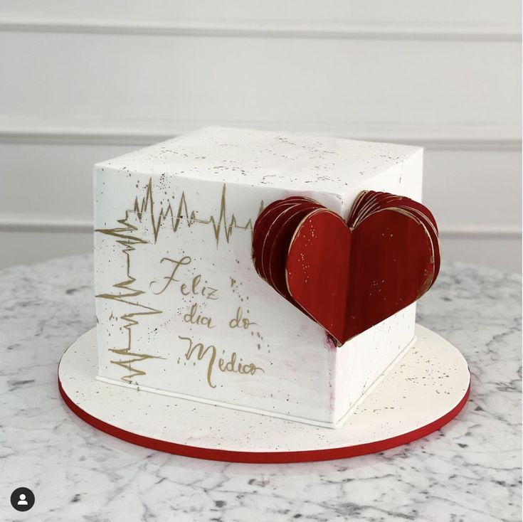 a cake that is shaped like a heart on top of a plate with writing on it