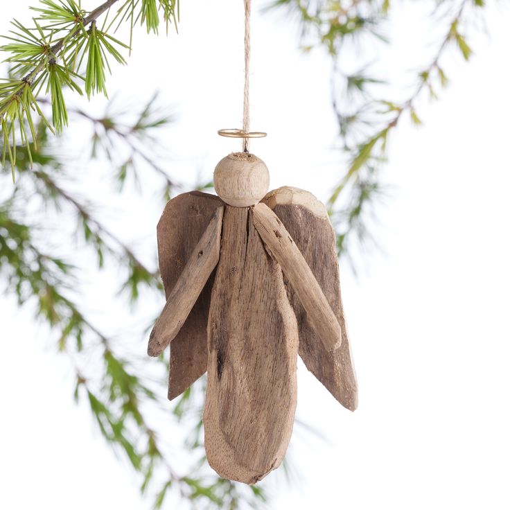 a wooden angel ornament hanging from a tree branch