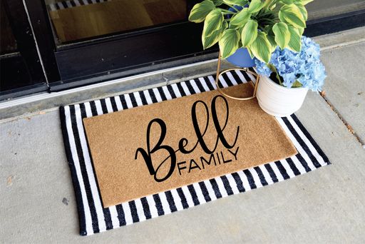 a door mat with the word bell family on it next to a potted plant