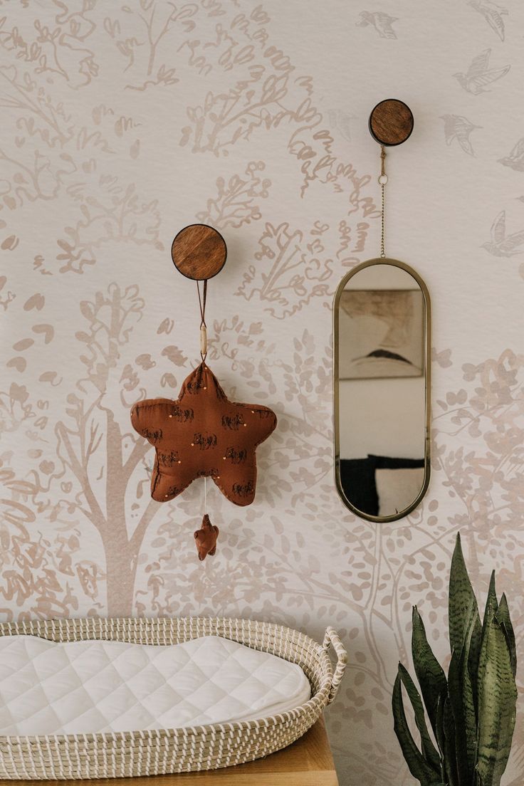 a baby crib next to a wall with a mirror hanging on it's side