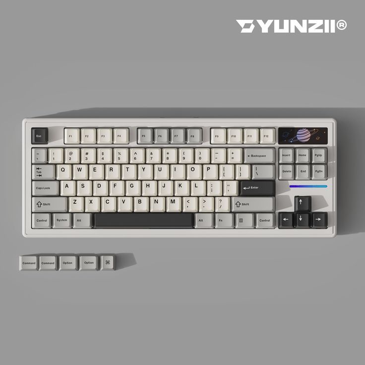 a computer keyboard and mouse sitting next to each other on a gray surface with the word dynzil above it