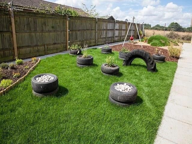 an outdoor garden with tire planters on the grass