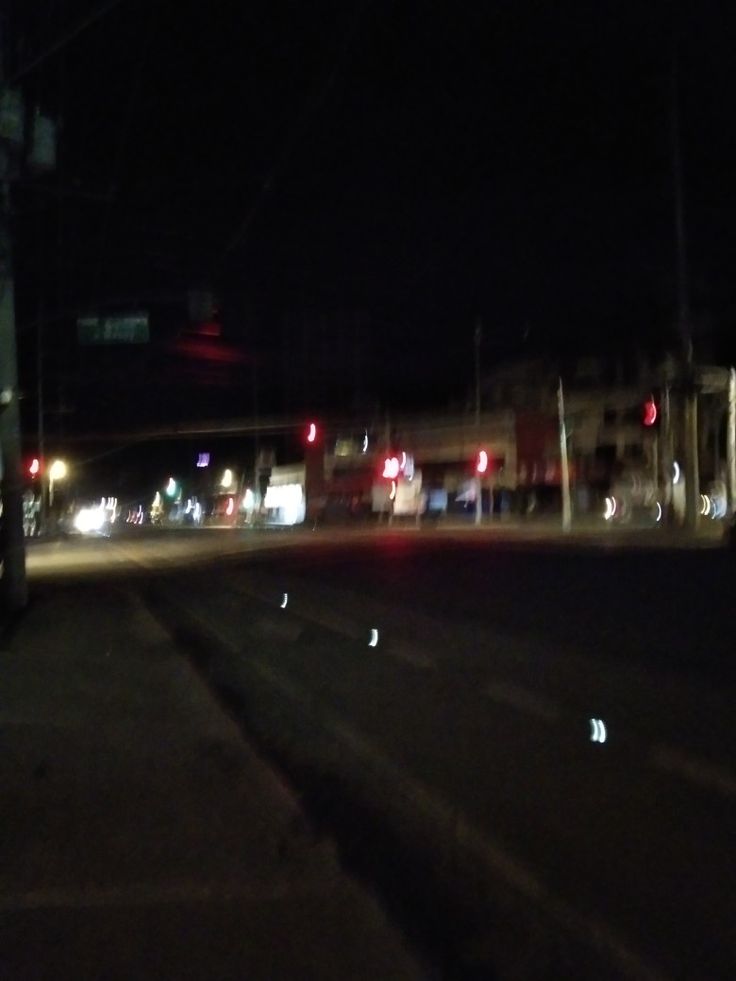 an empty street at night with traffic lights