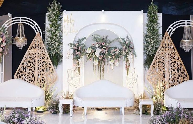 an elaborately decorated stage with white furniture and flowers