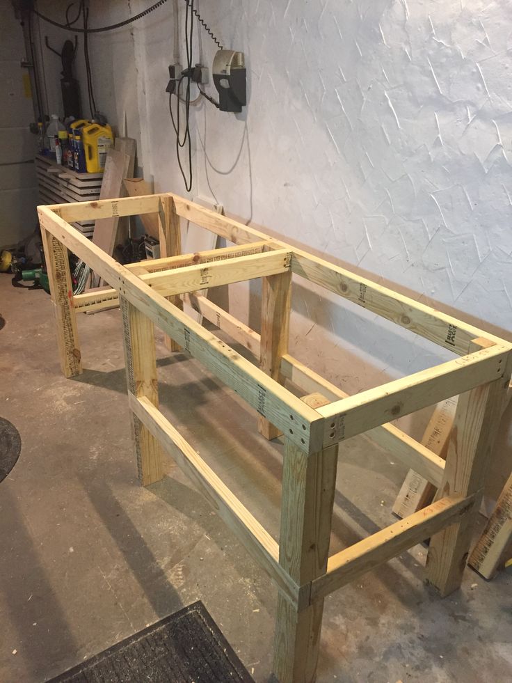 an unfinished wooden bench sitting in a garage