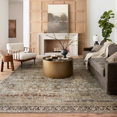 a living room filled with furniture and a large rug on top of a hard wood floor