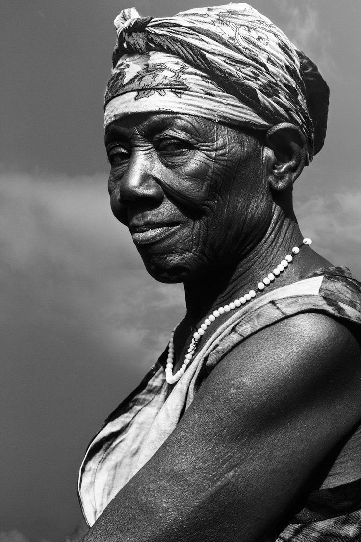 an old woman wearing a head wrap and pearls