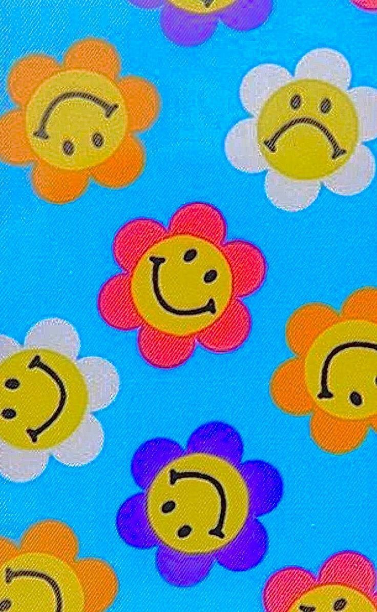 a bunch of flowers with faces drawn on them in different colors and shapes, all against a blue background