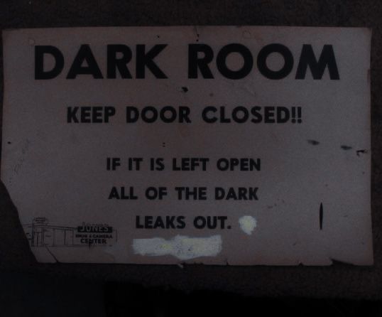 a sign that is on the side of a door saying, dark room keep door closed if it is left open all of the dark leaks out