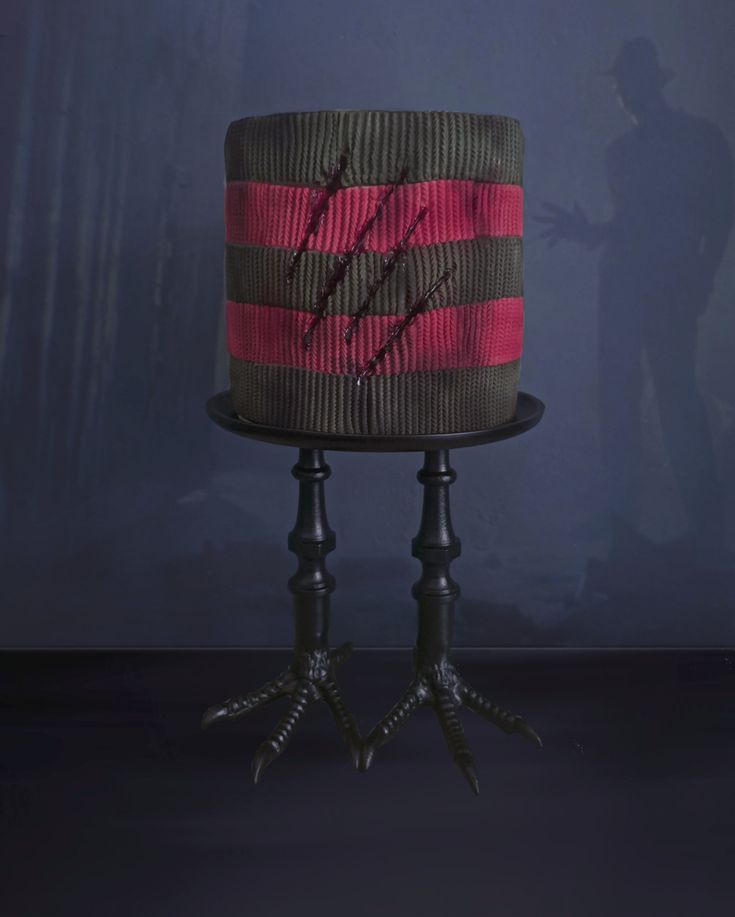 a cake sitting on top of a black table next to a blue wall in the background