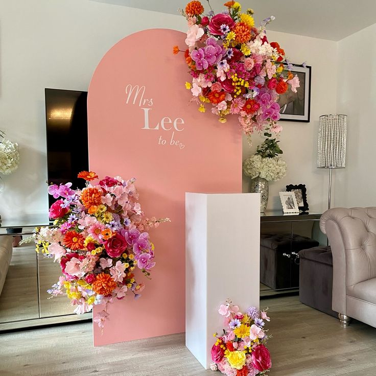 the flowers are hanging on the wall in front of the couches and chairs at the reception