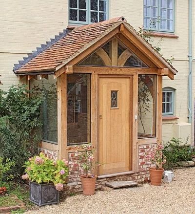 a small wooden building with potted plants outside