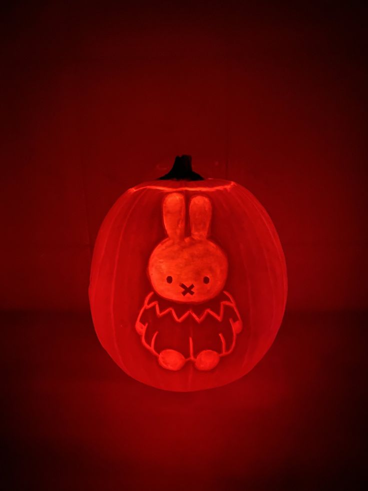 a carved pumpkin with an image of a rabbit on it's face in the dark