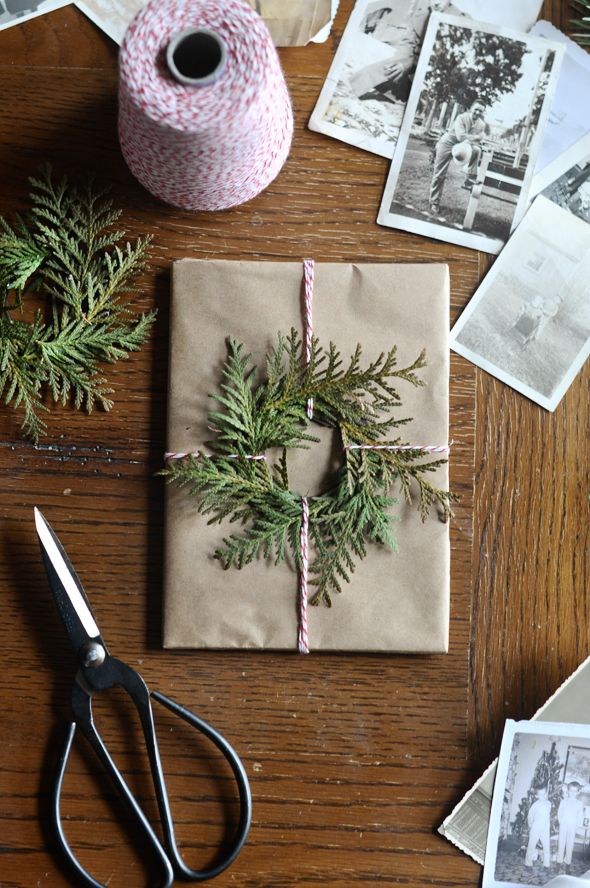 a wrapped present sitting on top of a wooden table next to scissors and other items