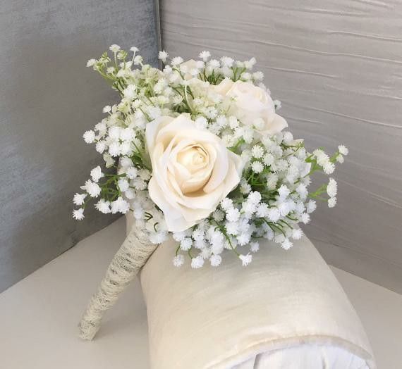 a bouquet of white flowers sitting on top of a pillow