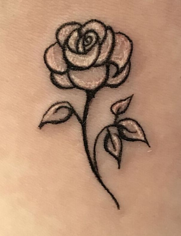 a rose tattoo on the back of a woman's stomach