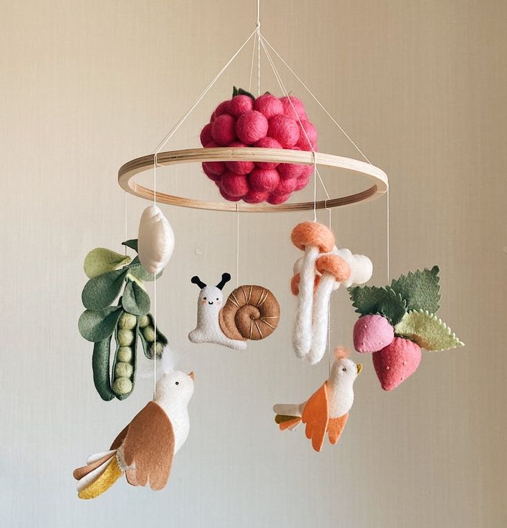 a mobile made out of felt with animals and fruits hanging from it