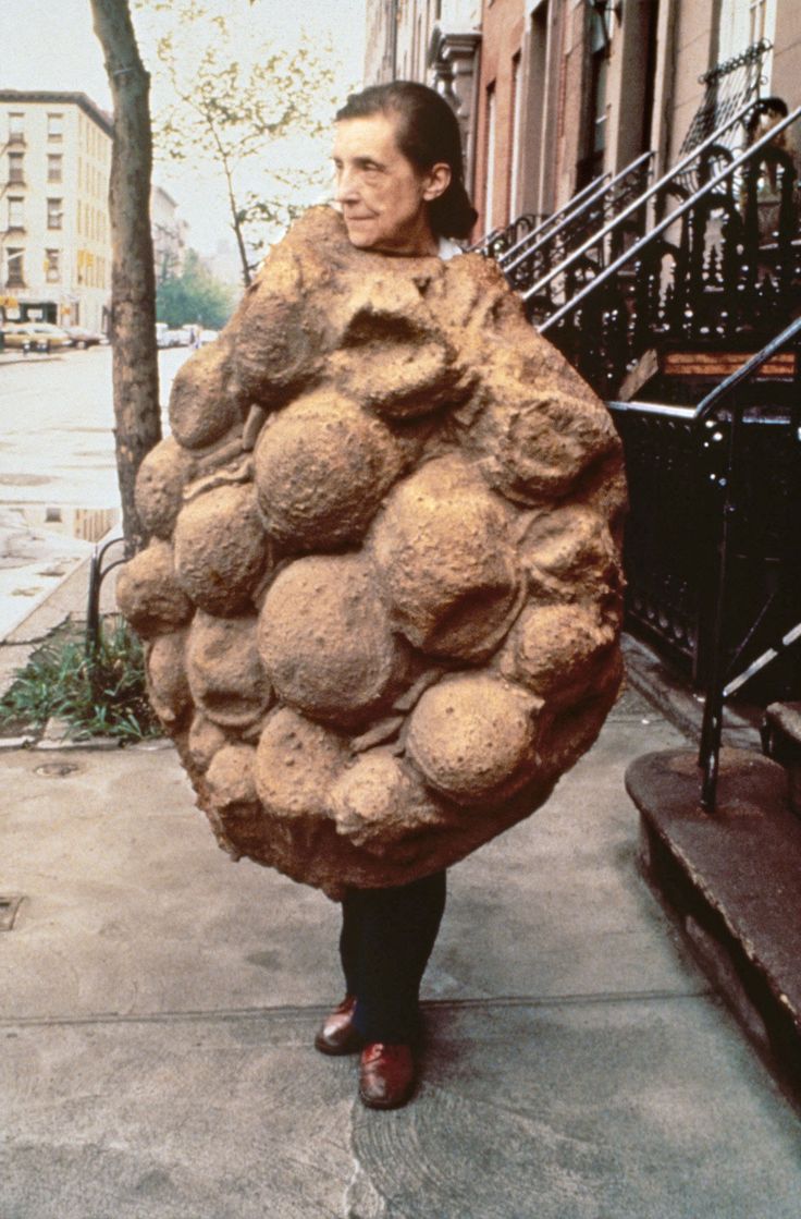 a man is walking down the sidewalk carrying a large rock