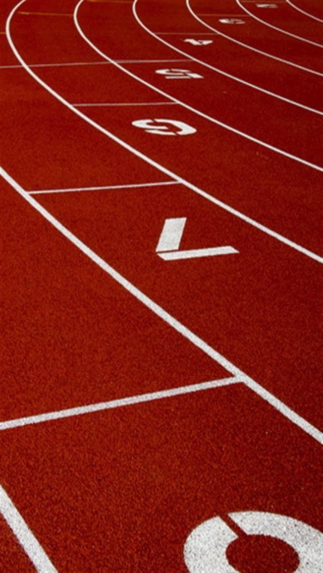 an empty running track with numbers painted on the side and white lines in the middle