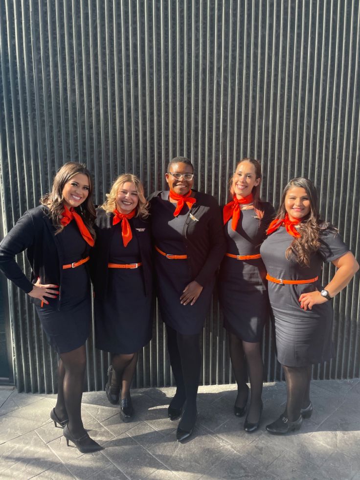 four women in business attire posing for the camera