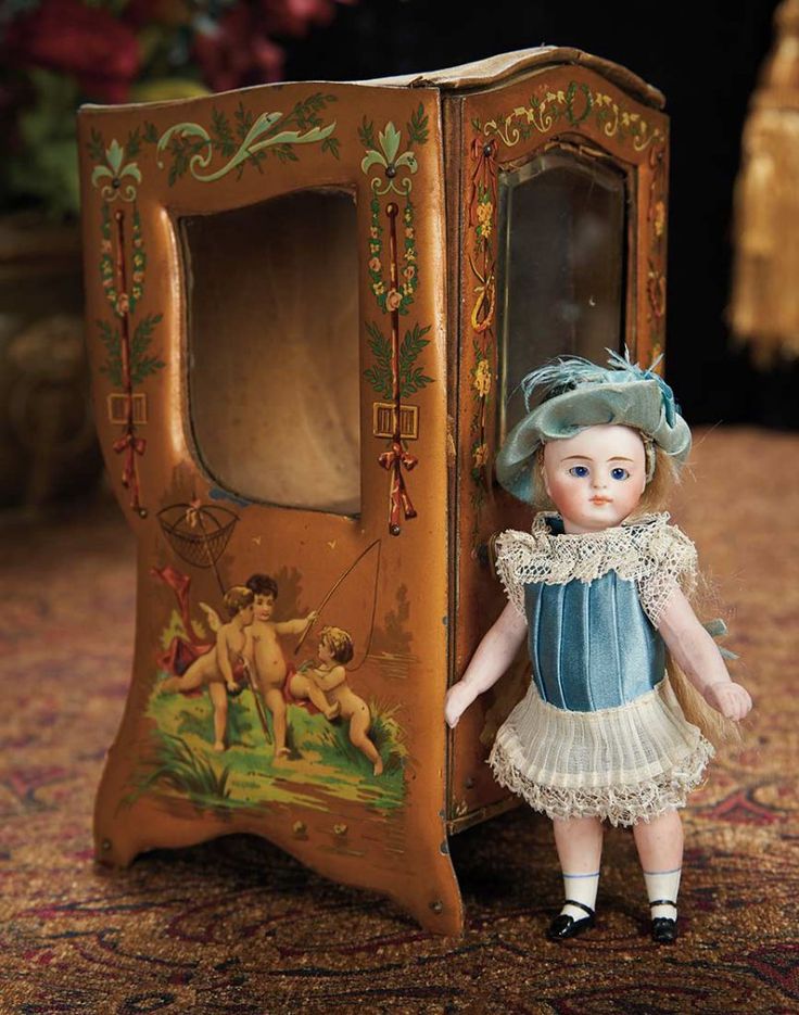 a doll is standing next to an old fashioned toy phone case on the floor in front of a carpeted area