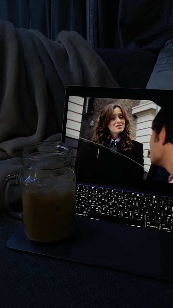 an open laptop computer sitting on top of a table next to a cup of coffee