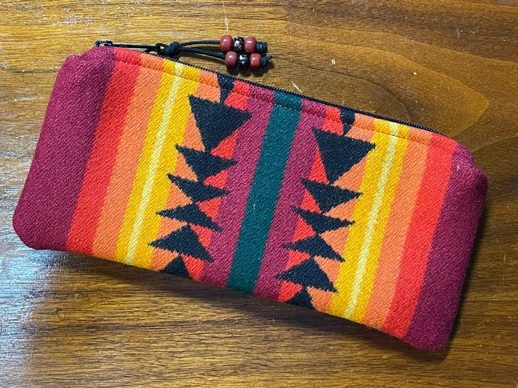 Unlined Clutch / Travel Bag / Cosmetic Bag handcrafted from Pendleton® Coat Weight wool Size:  5 inches tall, 10 3/4 inches wide Features: - Heavy duty purse zipper with leather zipper pull with glass crow beads for extra detail  - Unlined so your can enjoy the reversible pattern on the inside too - Inner seams finished Note: Accessories shown for demonstration and are not included Just the right size for a small wallet, phone, cosmetics, medications, jewelry, hair accessories or whatever More N Pendleton Coat, Jewelry Hair Accessories, Large Travel Bag, Rainbow Ribbon, Dog Walking Bag, Jewelry Hair, Valentines Gifts For Him, Wallet Gifts, Night Owl